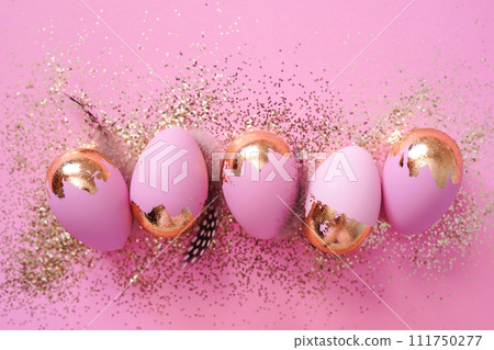 Easter party concept. Easter eggs with golden glitter on pink background Easter party concept. Easter eggs with golden glitter on pink background 111750277