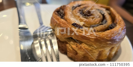 freshly baked Cinnamon rolls or cinnamon bun with raisins and vanilla also icing sugar ridiculously good 111750395