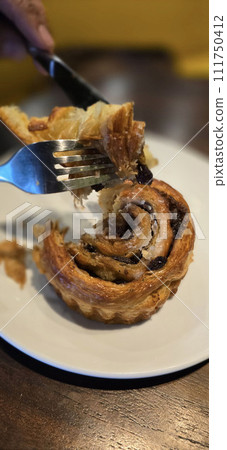 freshly baked Cinnamon rolls or cinnamon bun with raisins and vanilla also icing sugar ridiculously good 111750412