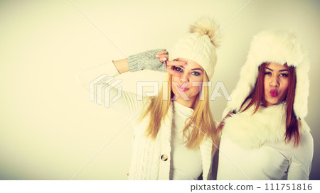 Two girls in warm winter clothing having fun. 111751816