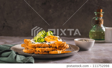 Toasts with cream cheese, cucumber, poached egg and sesame seeds on a plate web banner Toasts with cream cheese, cucumber, poached egg and sesame seeds on a plate web banner 111752098