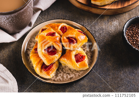 Pepperoni buns with cheese and sausage on a plate on the table Pepperoni buns with cheese and sausage on a plate on the table 111752105