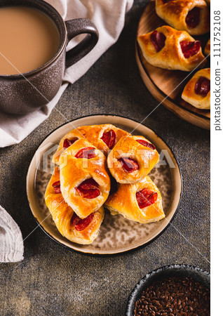 Pepperoni buns with cheese and sausage on a plate on the table vertical view 111752108