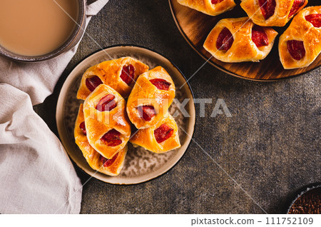 Appetizing envelopes with cheese and pepperoni sausage on a plate on the table top view Appetizing envelopes with cheese and pepperoni sausage on a plate on the table top view 111752109