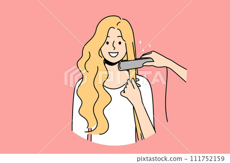 Woman at hairdresser appointment using hair straightener to straighten curls before party or date Woman at hairdresser appointment using hair straightener to straighten curls before party or date 111752159