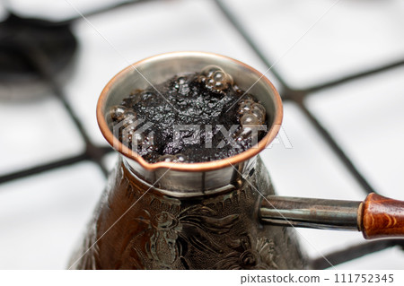 Coffee is brewed in retro cezve on stove 111752345