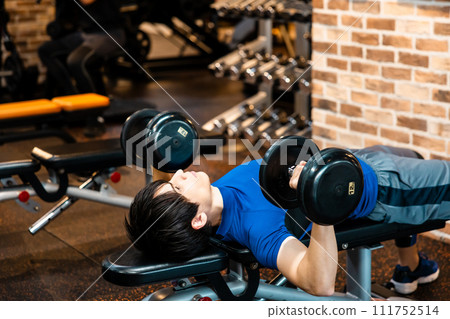 Man doing weight training at the gym Man doing weight training at the gym 111752514