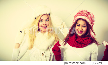Two smiling girls in warm winter clothing. Two smiling girls in warm winter clothing. 111752919
