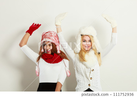 Two girls warm winter clothing having fun. 111752936