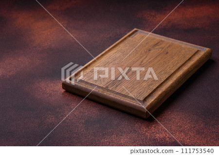 Empty rectangular wooden cutting board on textured concrete background Empty rectangular wooden cutting board on textured concrete background 111753540