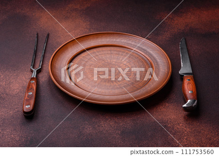 Empty ceramic round plate on dark textured concrete background 111753560
