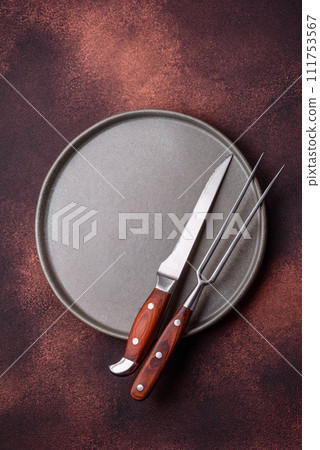 Empty ceramic round plate on dark textured concrete background 111753567