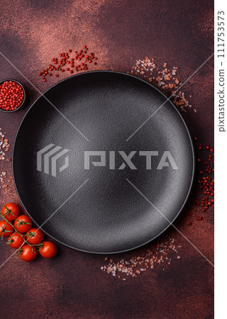 Empty ceramic round plate on dark textured concrete background Empty ceramic round plate on dark textured concrete background 111753573
