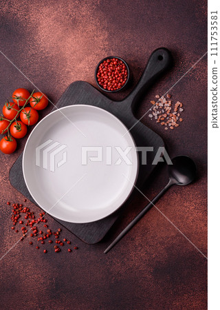 Empty ceramic round plate on dark textured concrete background Empty ceramic round plate on dark textured concrete background 111753581