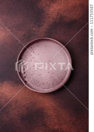 Empty ceramic round plate on dark textured concrete background Empty ceramic round plate on dark textured concrete background 111753587