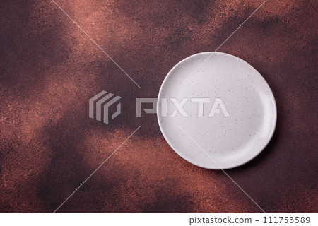 Empty ceramic round plate on dark textured concrete background 111753589