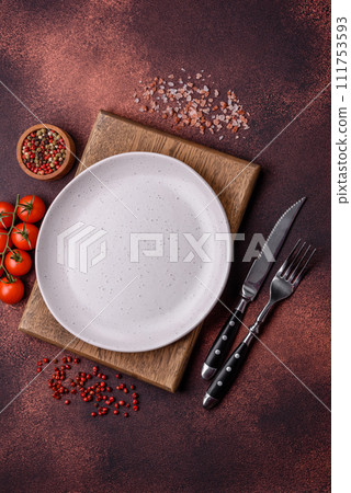 Empty ceramic round plate on dark textured concrete background Empty ceramic round plate on dark textured concrete background 111753593