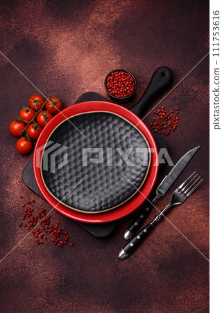 Empty ceramic round plate on dark textured concrete background Empty ceramic round plate on dark textured concrete background 111753616