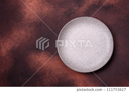 Empty ceramic round plate on dark textured concrete background 111753627