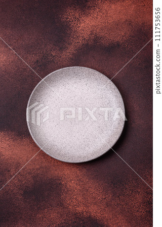 Empty ceramic round plate on dark textured concrete background 111753656