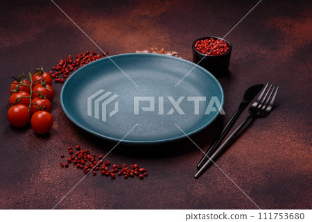 Empty ceramic round plate on dark textured concrete background 111753680