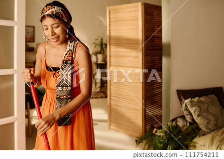 Girl with broom doing domestic chores Girl with broom doing domestic chores 111754211