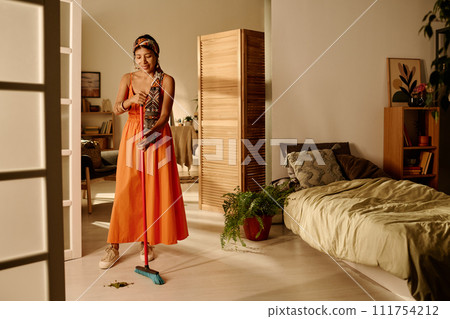 Cleaning floor of bedroom with broom Cleaning floor of bedroom with broom 111754212