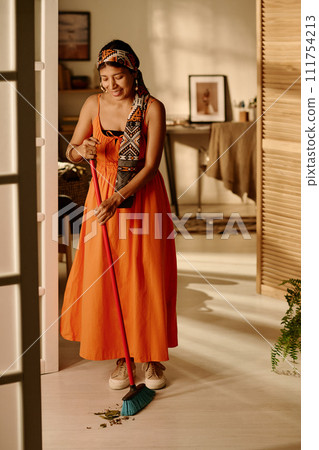 Housewife cleaning floor with broom Housewife cleaning floor with broom 111754213