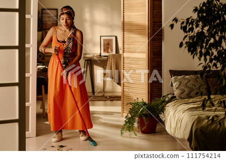 Young woman cleaning floor in bedroom Young woman cleaning floor in bedroom 111754214