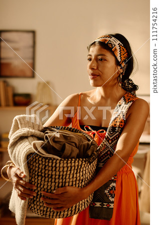 Young woman with basket of clothes Young woman with basket of clothes 111754216