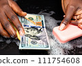 AI-generated content. Money laundering concept. Hands washing 100 dollars banknote with soap 111754608