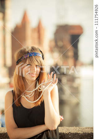Flapper girl woman in1920s style standing on the street Flapper girl woman in1920s style standing on the street 111754926