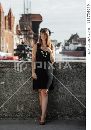 Flapper girl woman in1920s style standing on the street 111754929