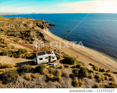 Caravan with solar panels on roof camp on coast, Spain. Aerial view. 111755327