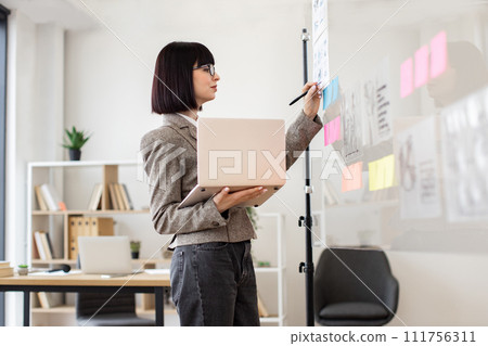 Female administrative manager preparing for presentation at work. 111756311