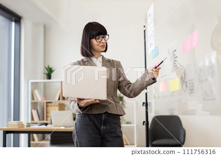 Female administrative manager preparing for presentation at work. Female administrative manager preparing for presentation at work. 111756316