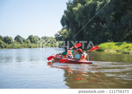 a team of athletes on a canoe overcomes obstacles floating on the river 111756373