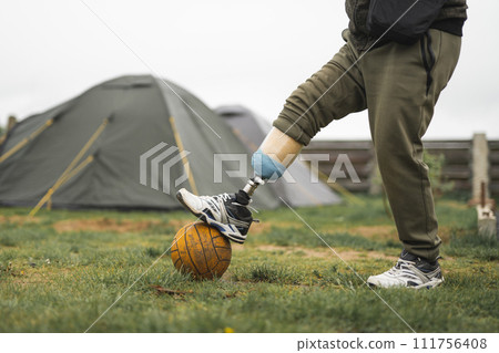 a man with a prosthetic leg is doing sports playing football 111756408