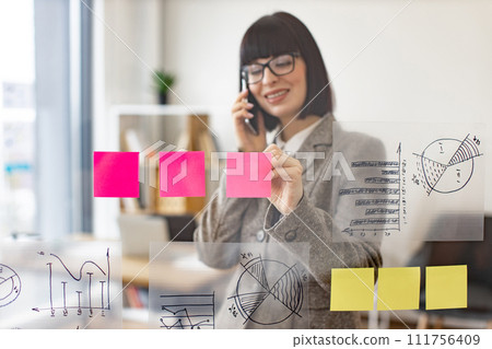 Female administrative manager preparing for presentation at work. Female administrative manager preparing for presentation at work. 111756409