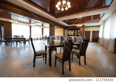 spacious interior of modern empty large restaurant with tables and chairs. 111756430