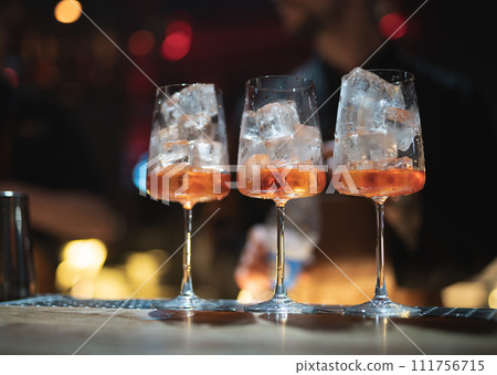 the bartender prepares a beautiful alcoholic cocktail at the bar counter 111756715