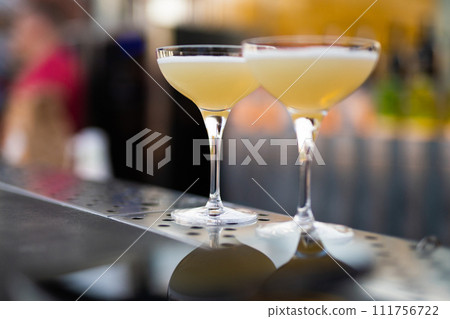 two beautiful yellow alcoholic cocktails on the bar counter two beautiful yellow alcoholic cocktails on the bar counter 111756722