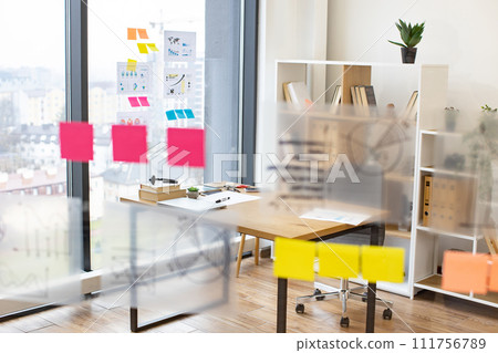 Modern bright office with transparent flip chart with stickers graphs and charts Modern bright office with transparent flip chart with stickers graphs and charts 111756789