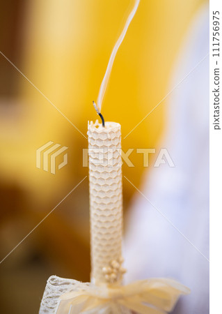 Beautifully burning candle held in hands in the church Beautifully burning candle held in hands in the church 111756975