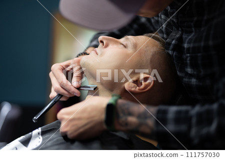 a man gets a haircut and a shave in a barbershop a man gets a haircut and a shave in a barbershop 111757030