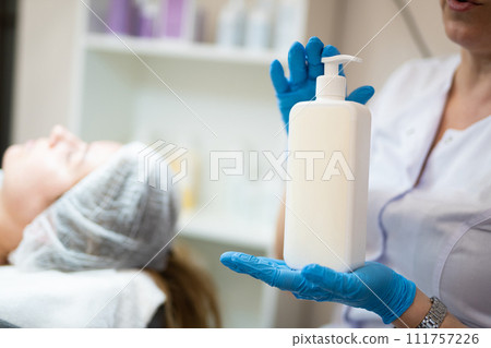 a cosmetologist holds a jar with a cosmetic product in his hands 111757226