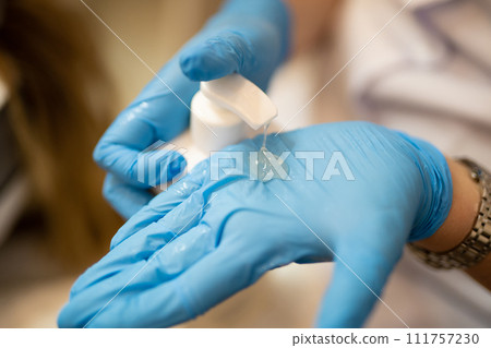 applying and rubbing the cosmetic product from the bottle into the hand 111757230