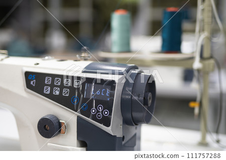 workers in an industrial garment factory sew clothes on sewing machine workers in an industrial garment factory sew clothes on sewing machine 111757288