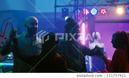 Dance partners waltzing at party, dancing in pairs on slow romantic music on dance floor. Cheerful couples enjoying waltz at discotheque, having fun with stage lights and drinks. Entertainment. 111757421