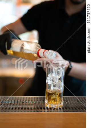 the bartender prepares a beautiful alcoholic cocktail at the bar counter 111757510
